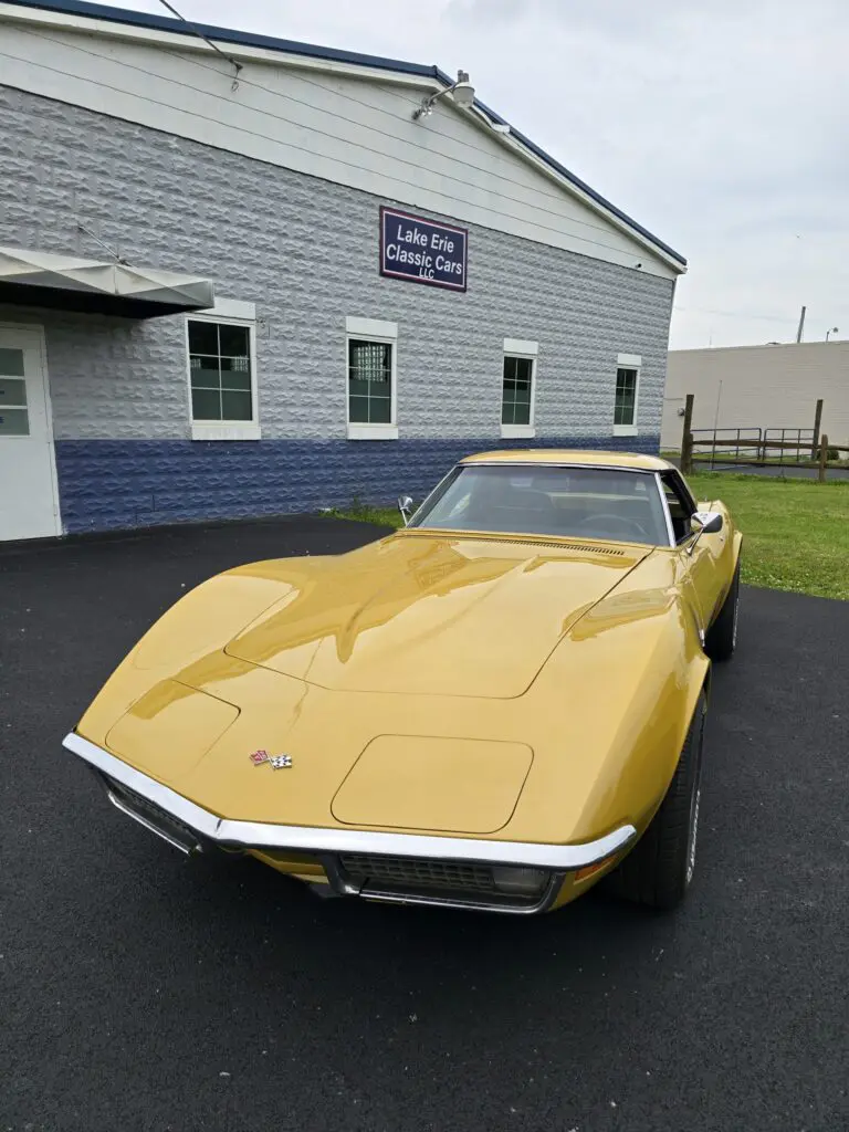 Yellow classic car parked outside a building.