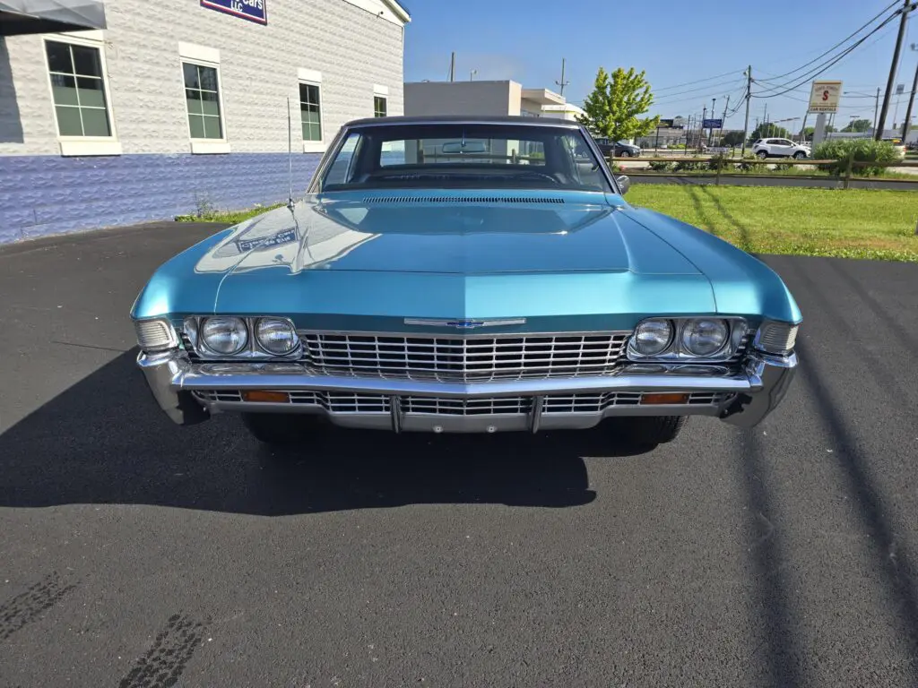 Blue vintage car parked outside building.