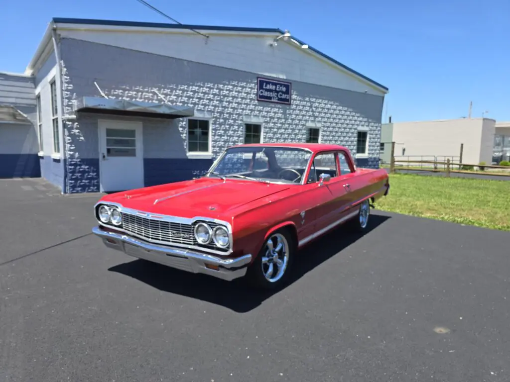 Red classic car parked near a building.