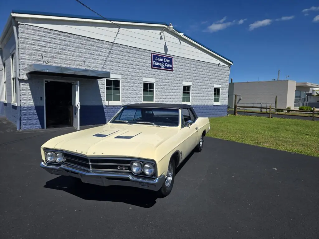 Classic car parked outside a garage building.