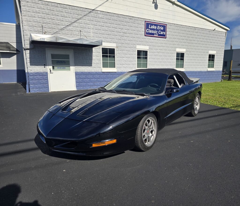 Black sports car parked outside building.