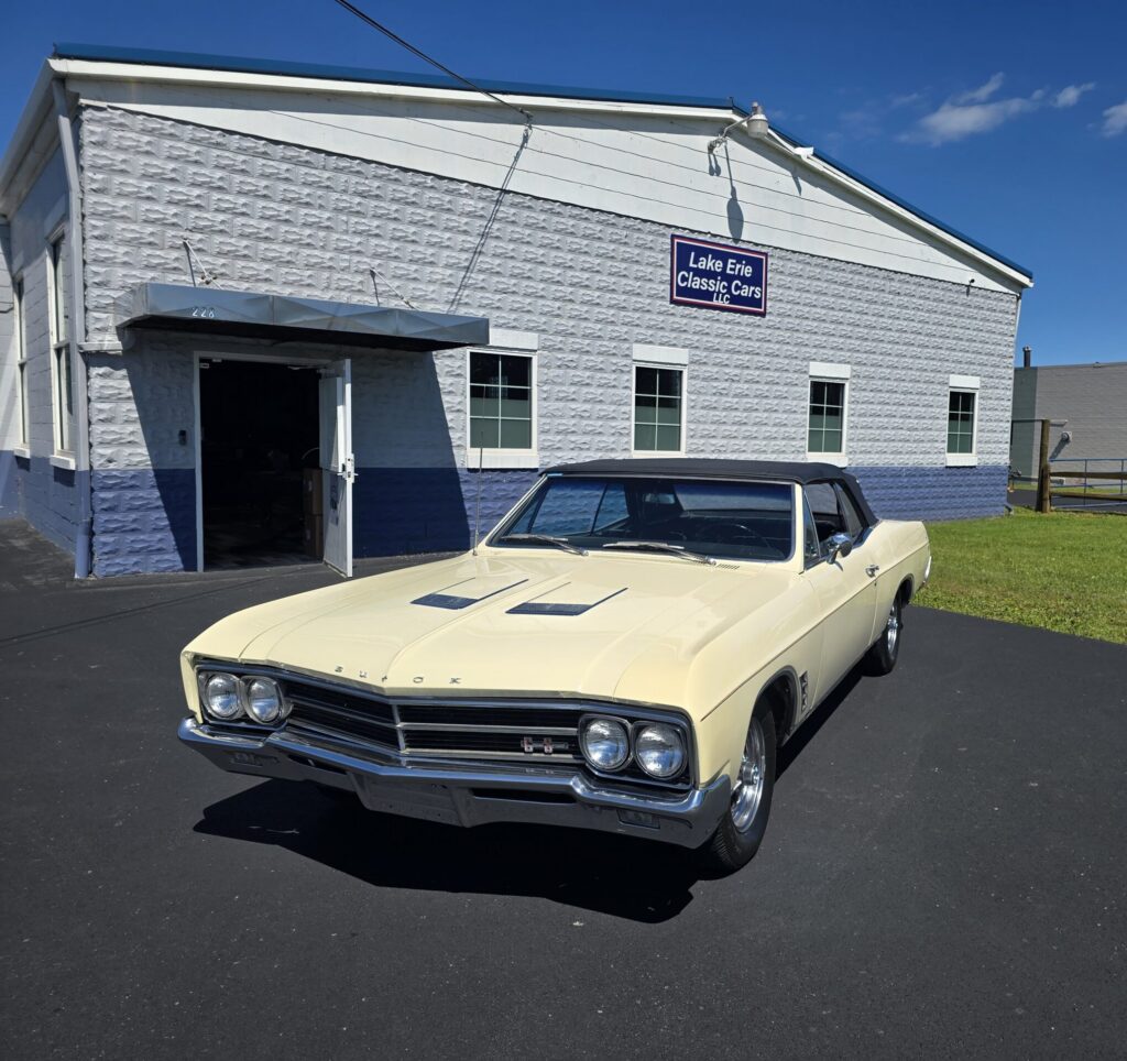 Classic car parked outside a garage building.